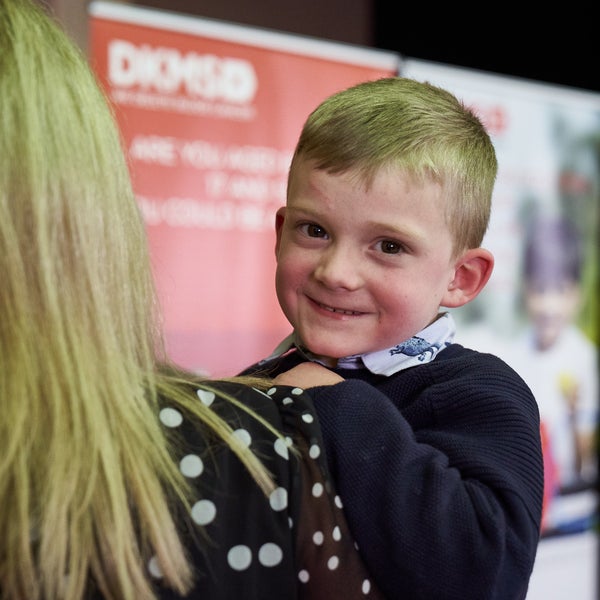 Alfie being held by his Mum, smiling into the camera.  Alfie being held by his Mum, smiling into the camera.