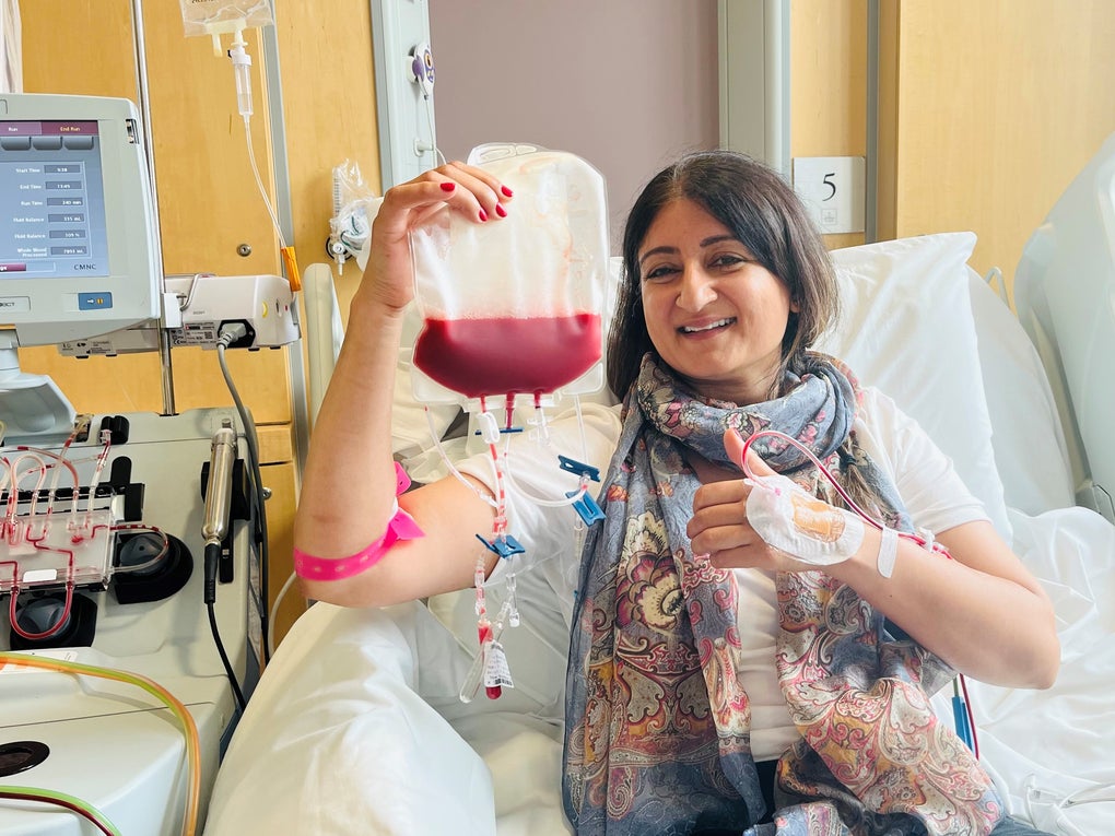 Asian stem cell donor smiling and holding a bag of stem cells Asian stem cell donor smiling and holding a bag of stem cells