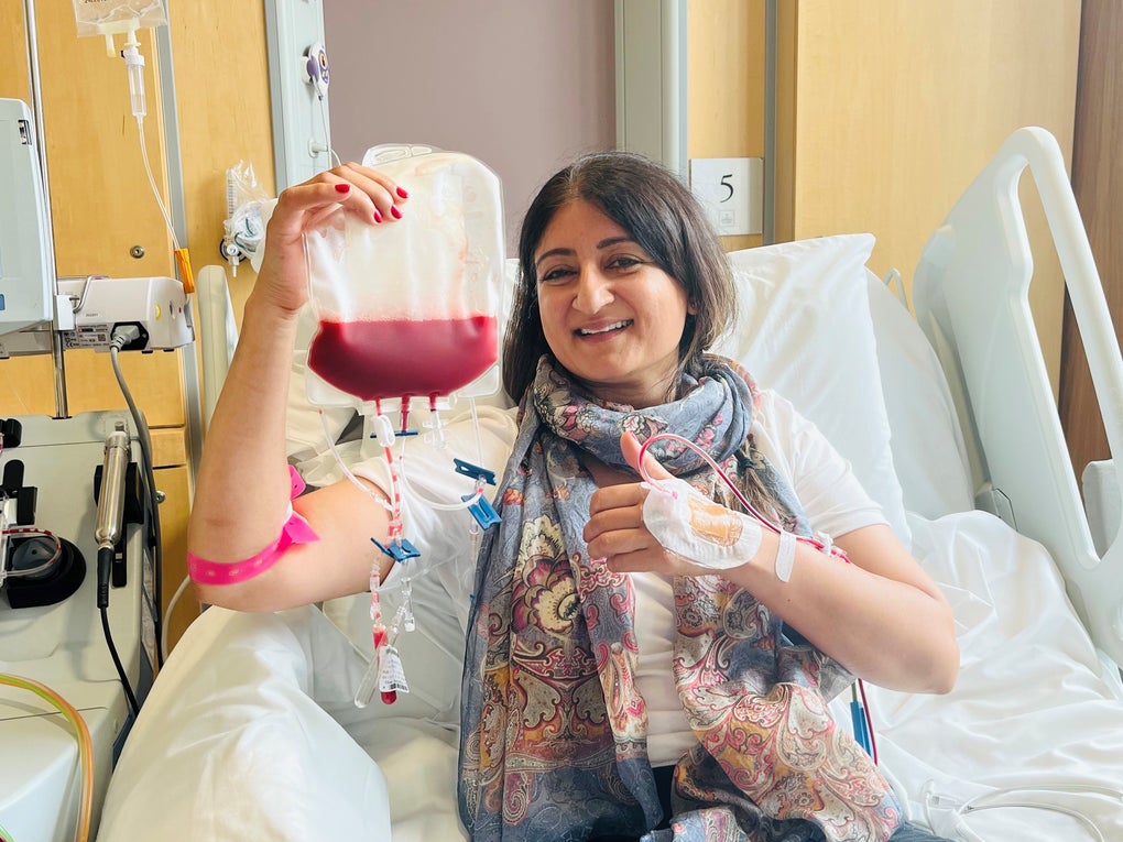 Asian stem cell donor smiling and holding a bag of stem cells Asian stem cell donor smiling and holding a bag of stem cells