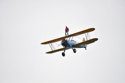 A plane flying with a person stood on top