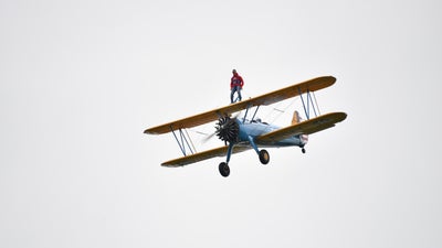A plane flying with a person stood on top