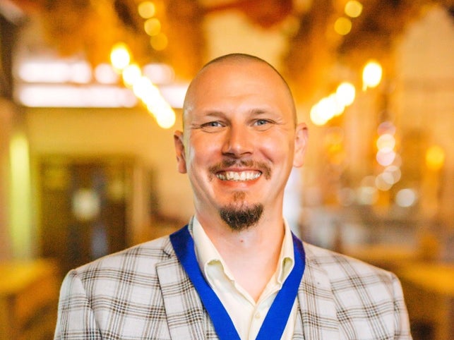 A photo of a middle aged white man smiling at the camera A photo of a middle aged white man smiling at the camera