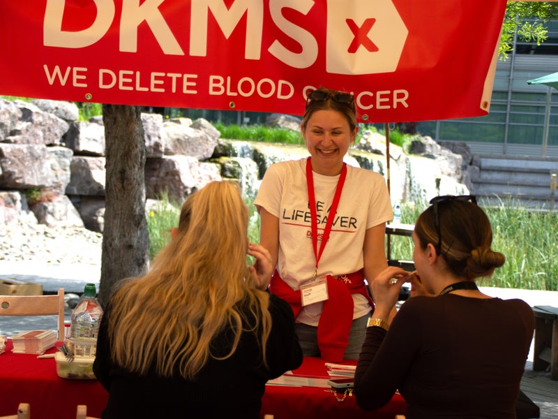 DKMS member of staff in white t-shirt registering two potential donors
