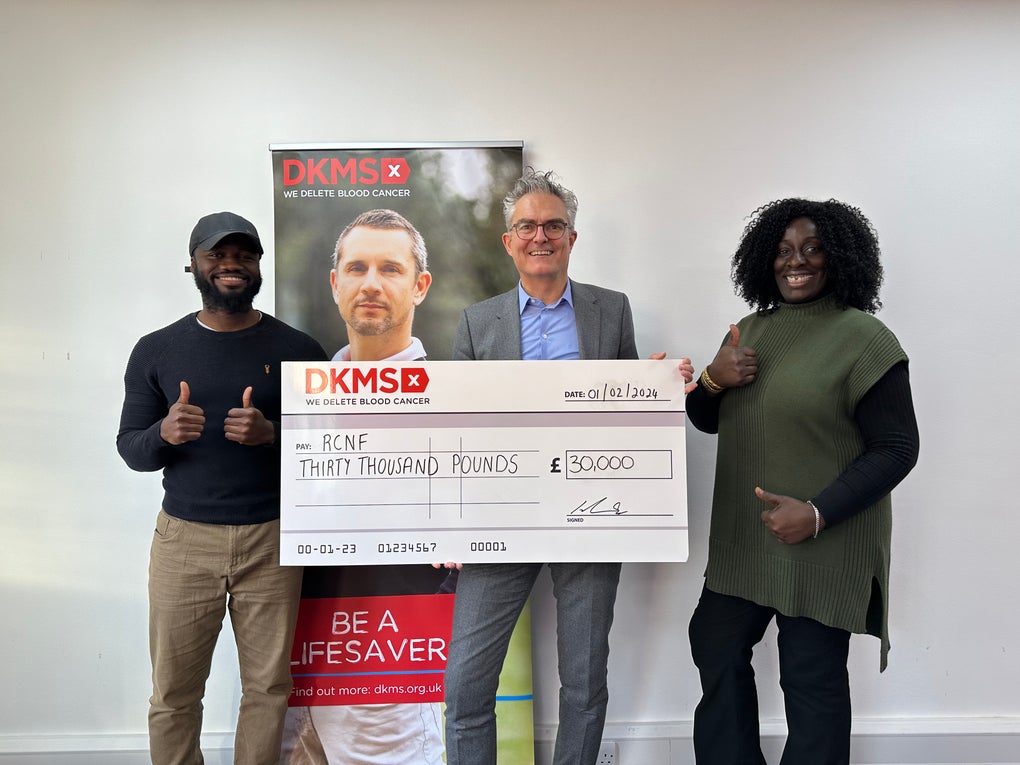 The CEO of DKMS holding up the cheque for RCNF partnership grant together with two team members The CEO of DKMS holding up the cheque for RCNF partnership grant together with two team members