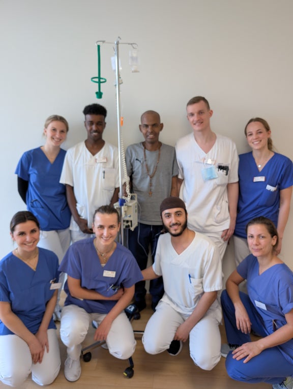 Patient standing with doctors Patient standing with doctors