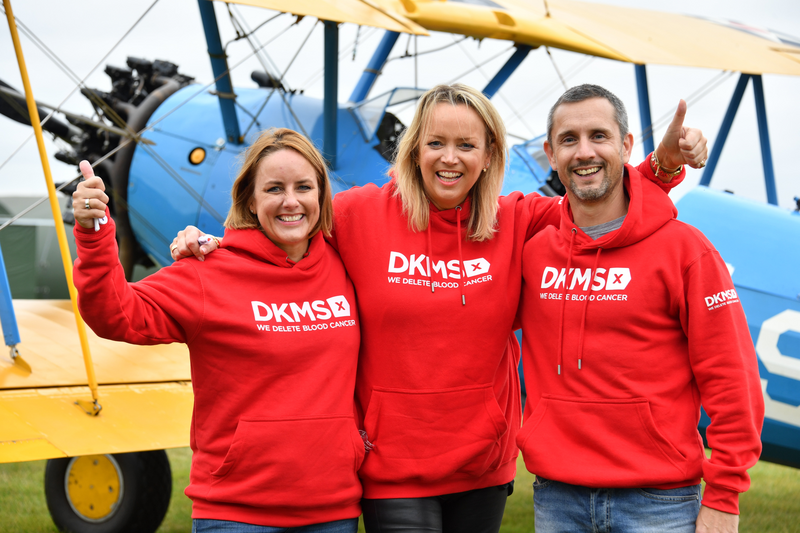 L - R Sally Hurman, Lisa Jackson and Peter McCleave in red DKMS jumpers in front of the aircraft