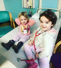Josie and Adeline sitting together on a hospital bed
