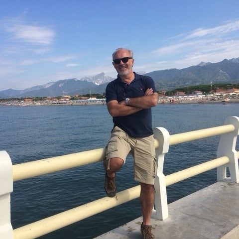 Elderly white man smiling and leaning on a railing Elderly white man smiling and leaning on a railing