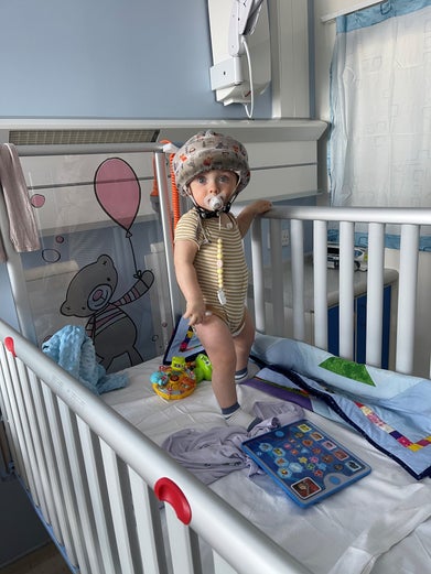 Gustavs wearing a protective hemet standing in a hosptal cot