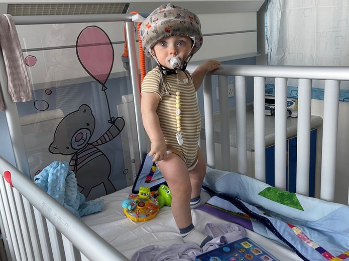 Gustavs wearing a protective hemet standing in a hosptal cot