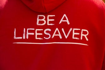 Back of red DKMS hoodie with 'Be a lifesaver' caption in white
