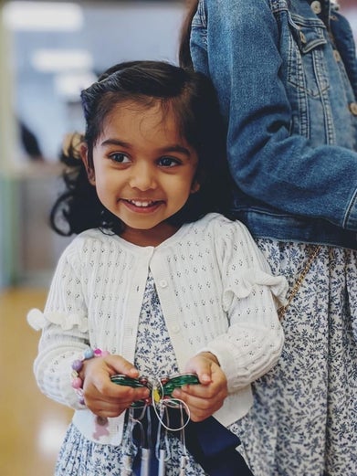 Esha holding a toy butterfly smiling 