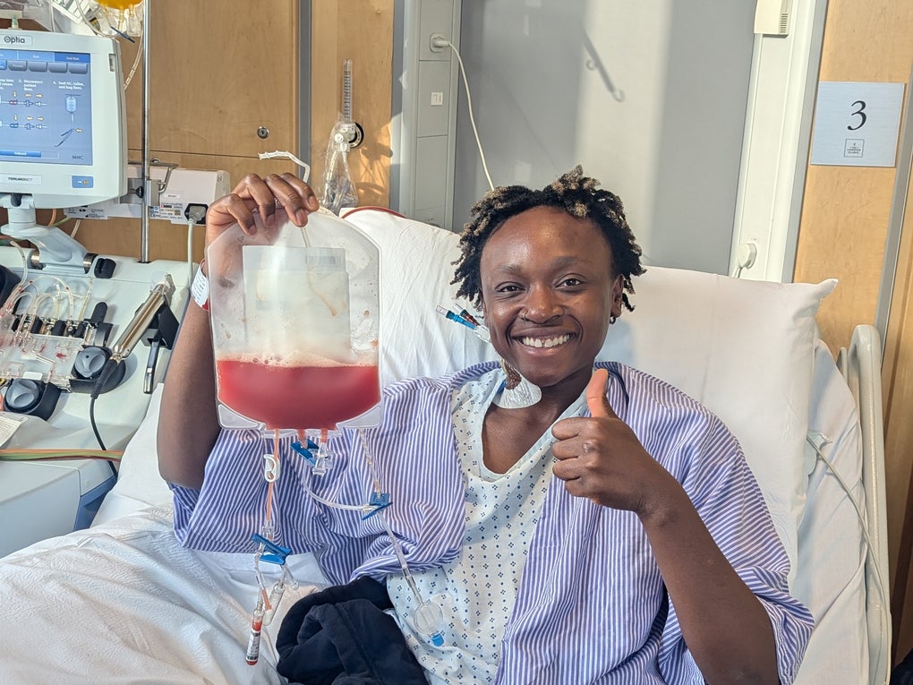 Black woman holding a bag of stem stells in a hospital bed and smiling Black woman holding a bag of stem stells in a hospital bed and smiling