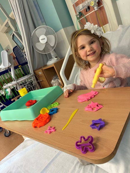 Emilia in hospital creating colourful flowers from modelling clay