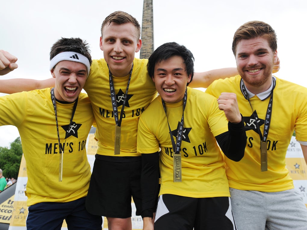 Four men in yellow t-shirts and medals Four men in yellow t-shirts and medals