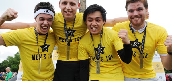 Four men in yellow t-shirts and medals