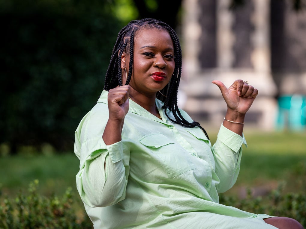 Image of a black woman with her thumbs up sitting in a park Image of a black woman with her thumbs up sitting in a park