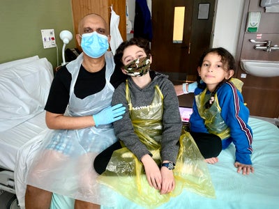 Hedley in hospital with his children next to him