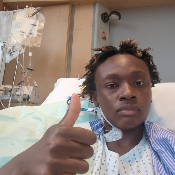 African woman giving a thumbs up in a hospital bed African woman giving a thumbs up in a hospital bed