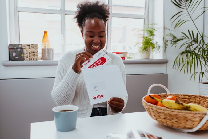 Woman opening envelope containg her requested swab kit Woman opening envelope containg her requested swab kit
