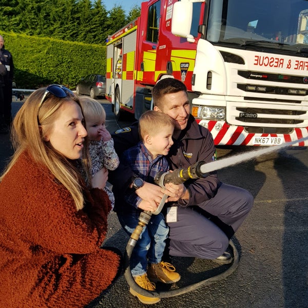Firefighter and his family holding a hose Firefighter and his family holding a hose