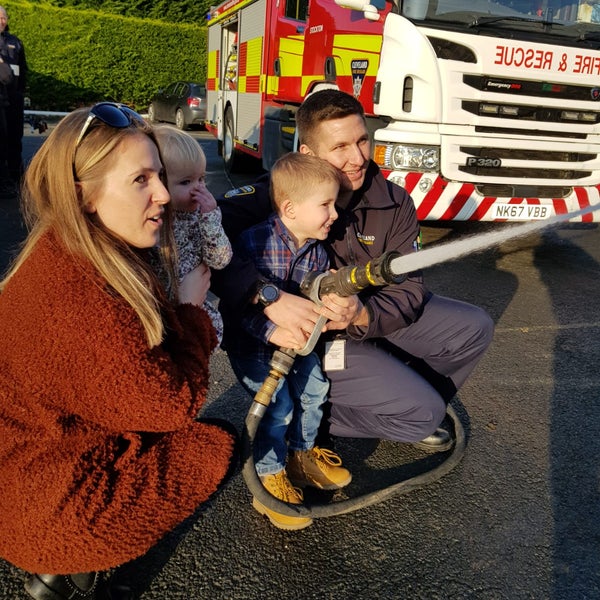Firefighter and his family holding a hose Firefighter and his family holding a hose