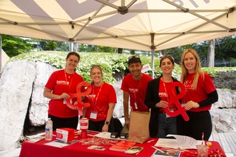 Ian (centre) with four DKMS colleagues wearing red DKMS t-shirts at a donor drive in May 2023