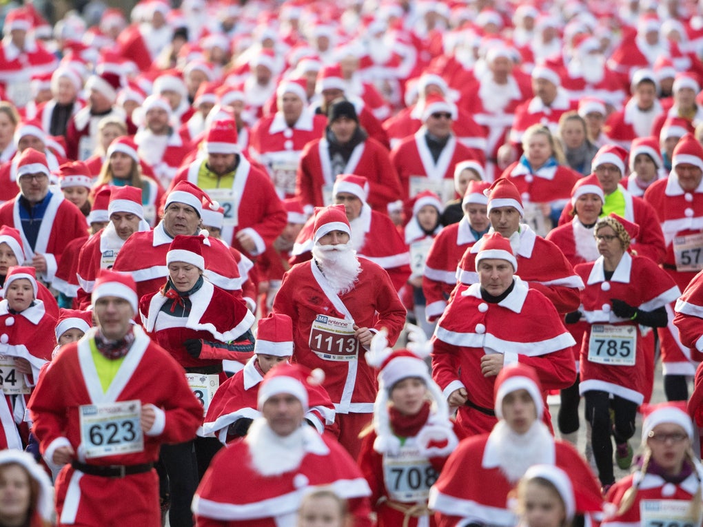 Lots of people dressed in santa suits running Lots of people dressed in santa suits running