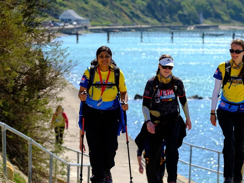 Three woman walking with the sea in the background Three woman walking with the sea in the background