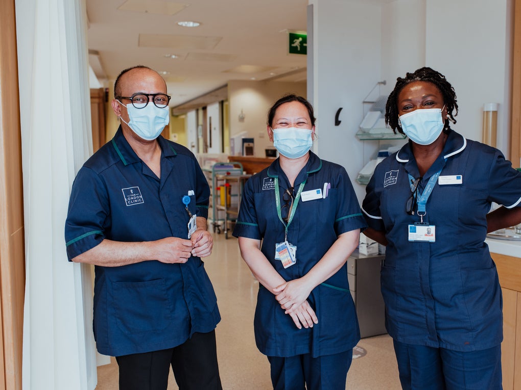 Three people dressed in medical tunics and masks in a hospital Three people dressed in medical tunics and masks in a hospital