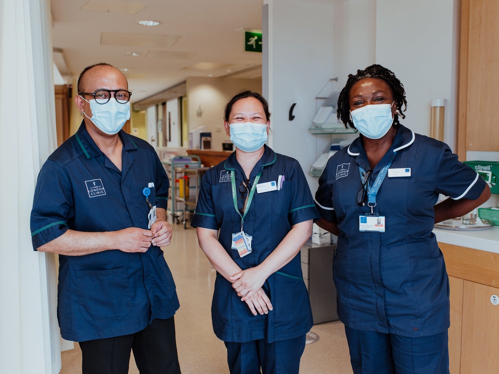 Three people dressed in medical tunics and masks in a hospital Three people dressed in medical tunics and masks in a hospital
