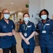 Three people dressed in medical tunics and masks in a hospital Three people dressed in medical tunics and masks in a hospital