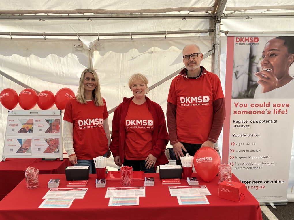 Three DKMS volunteers at an event registration stall Three DKMS volunteers at an event registration stall