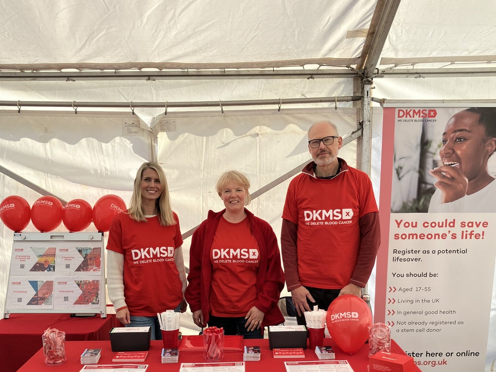 Three DKMS volunteers at an event registration stall Three DKMS volunteers at an event registration stall