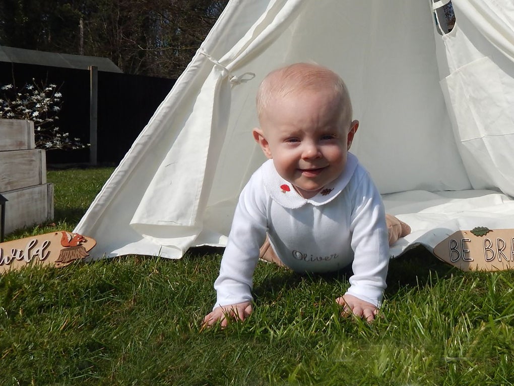 Olive as a baby crawling from a white play tent in the garden Olive as a baby crawling from a white play tent in the garden