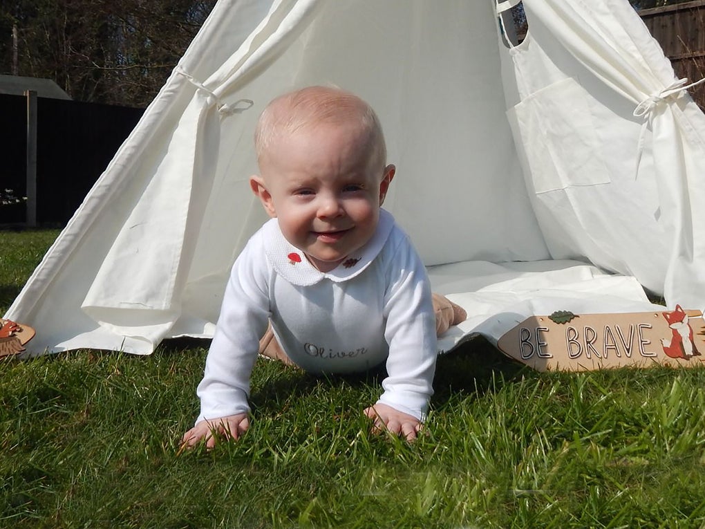 Olive as a baby crawling from a white play tent in the garden Olive as a baby crawling from a white play tent in the garden
