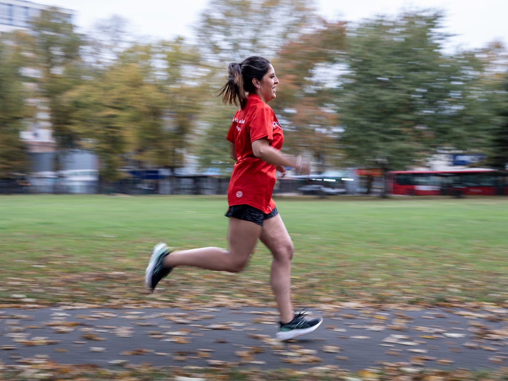 Woman in red top running through a park Woman in red top running through a park