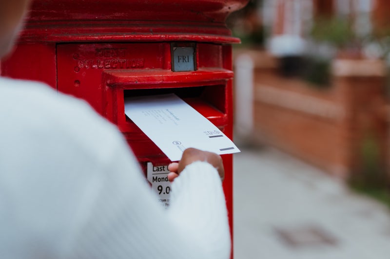 A swab kit being posted into a postbox