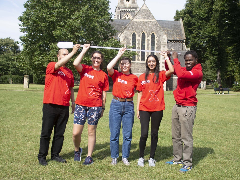 Group of people holding a giant swab Group of people holding a giant swab