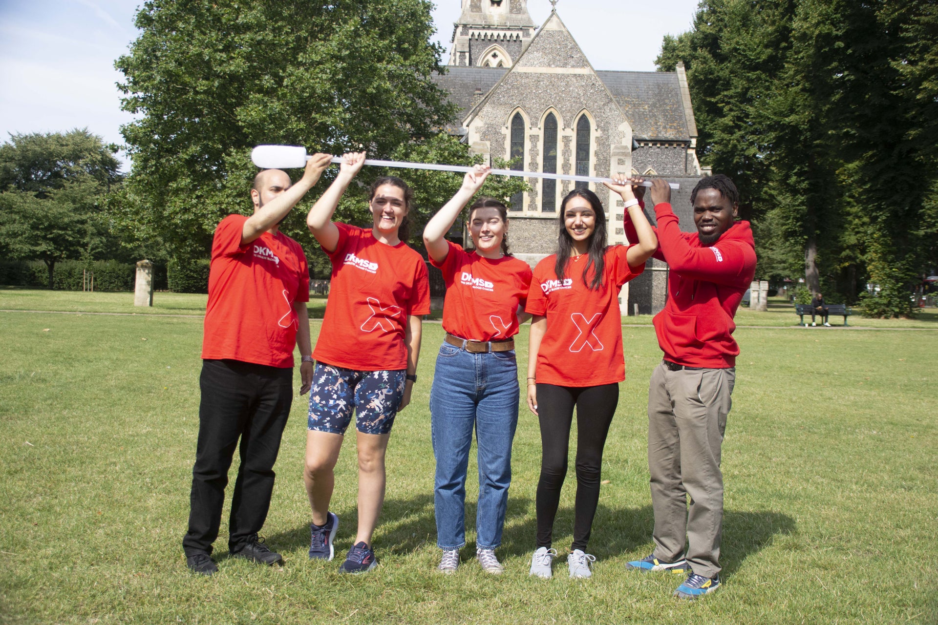 Group of people holding a giant swab Group of people holding a giant swab