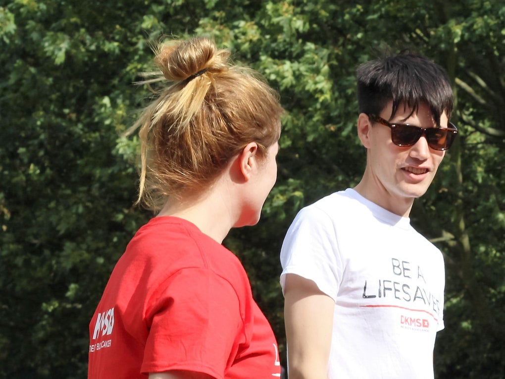 Four people wearing DKMS t-shirts chatting Four people wearing DKMS t-shirts chatting