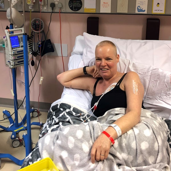 Elderly white woman lying in hospital bed and smiling connected to tubes  Elderly white woman lying in hospital bed and smiling connected to tubes