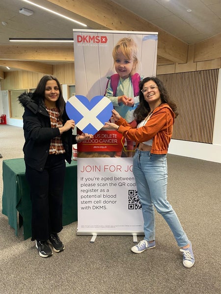 Two Volunteers at the Stirling Volunteer hub, holding up the Scottish flag