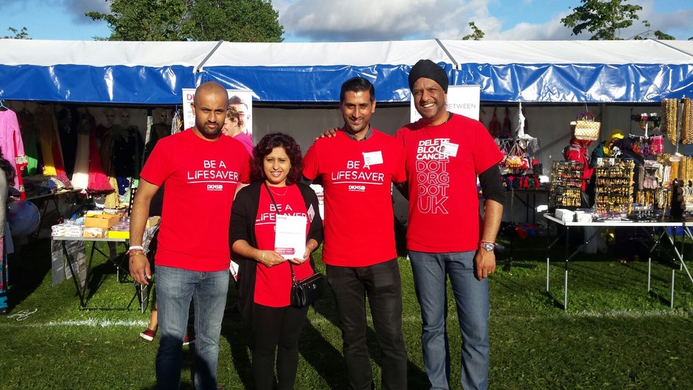 A group of four people stood outdoors wearing DKMS branded t-shirts