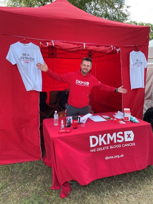 Male DKMS volunteer at a DKMS stand