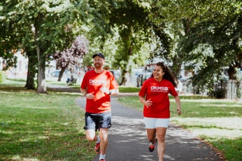 Man and woman running in DKMS t-shirts