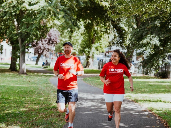 Man and woman running in DKMS t-shirts