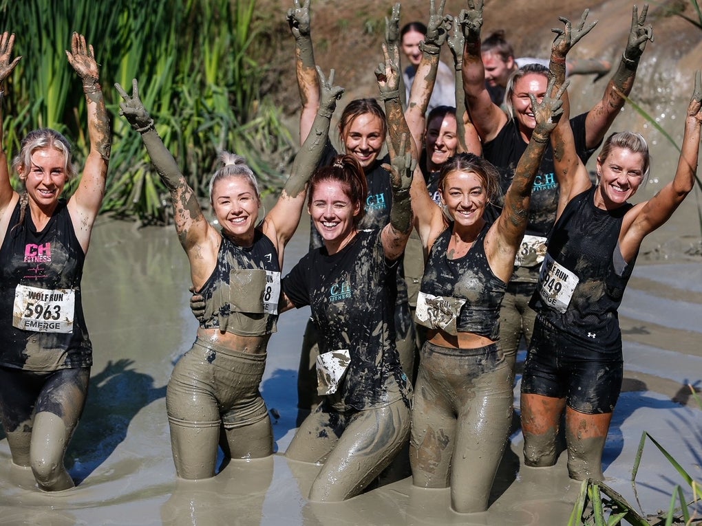 Group of women covered in mud on obstacle course Group of women covered in mud on obstacle course