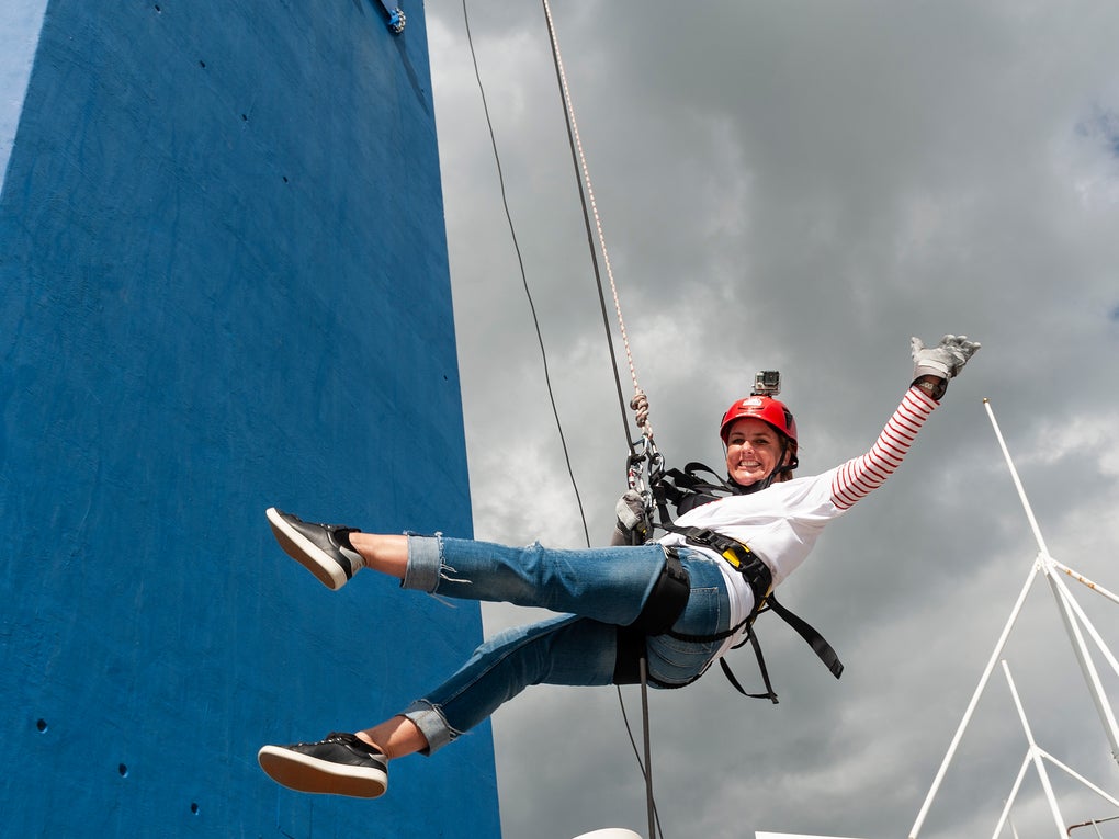 Sally on a harness waving to the camera as she abseils the Spinnaker Tower. Sally on a harness waving to the camera as she abseils the Spinnaker Tower.
