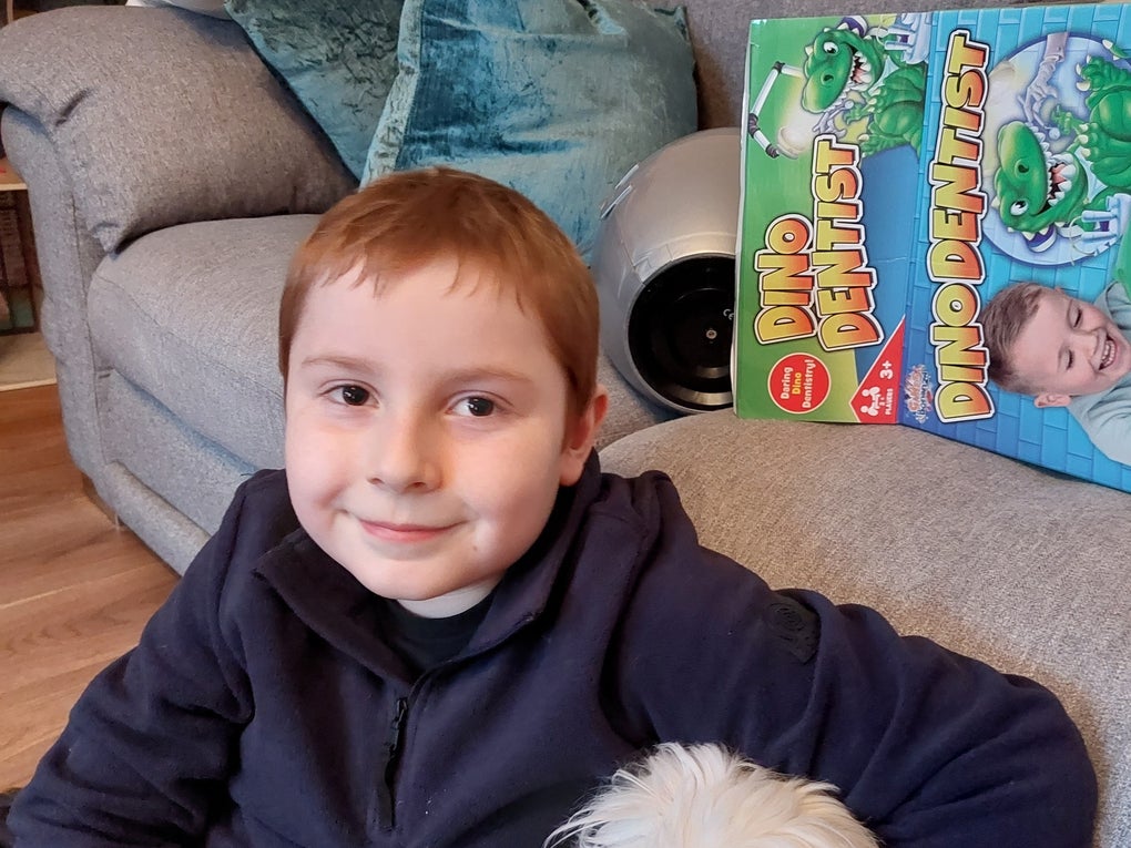 Bobby sitting on floor in front of as sofa cuddling a white dog Bobby sitting on floor in front of as sofa cuddling a white dog